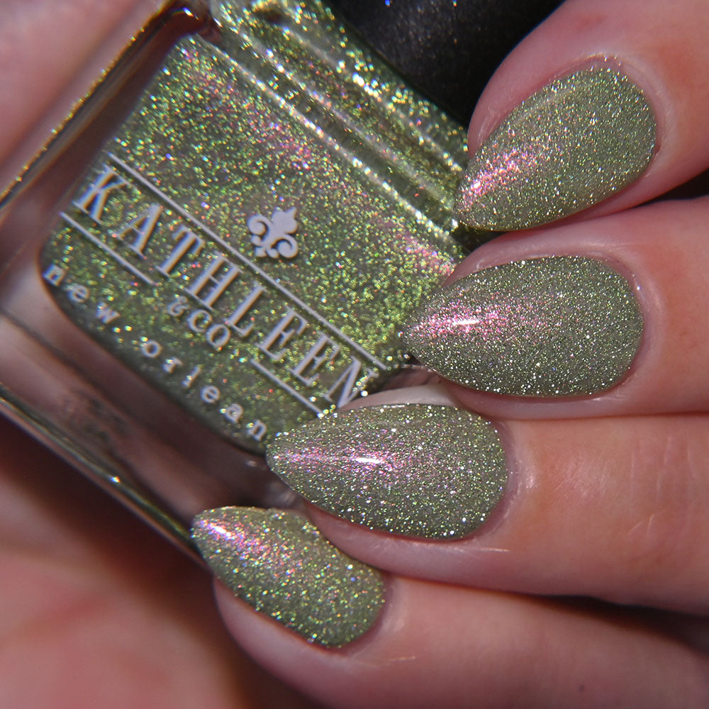 Nail polish with green reflective color with pink shimmer and &