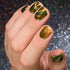 Hand with gold and green magnetic nail polish against a glittery background