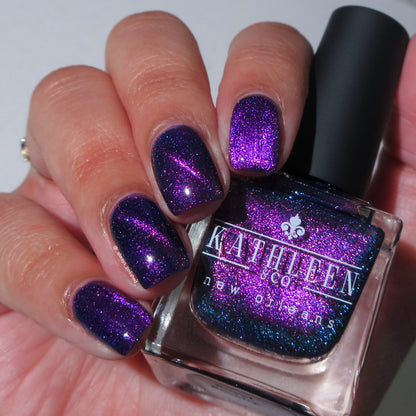 Purple glitter nail polish with a bottle of Kathleen &amp; Co. nail polish.