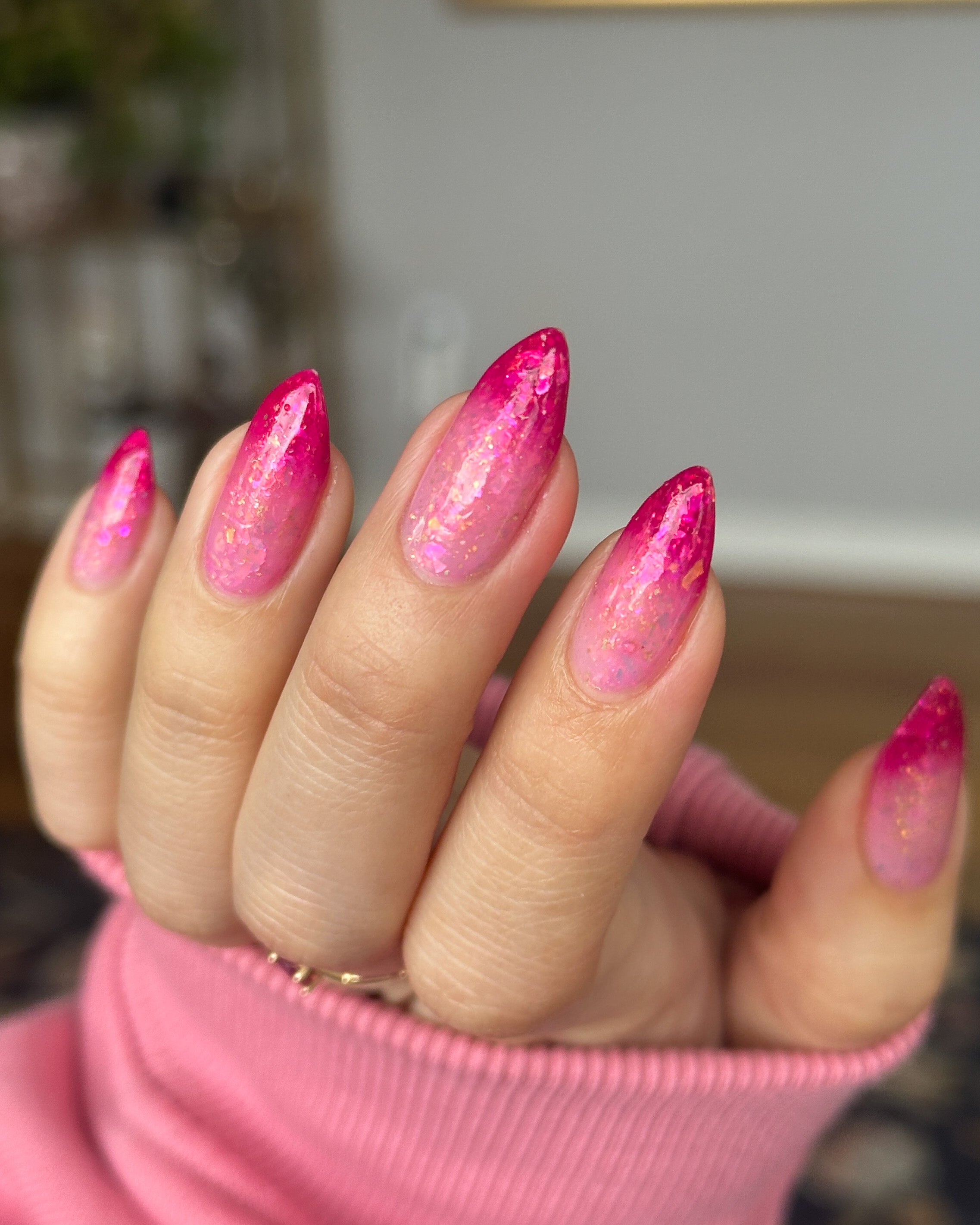 Close-up of a hand with pink thermal nails wearing a pink sleeve.