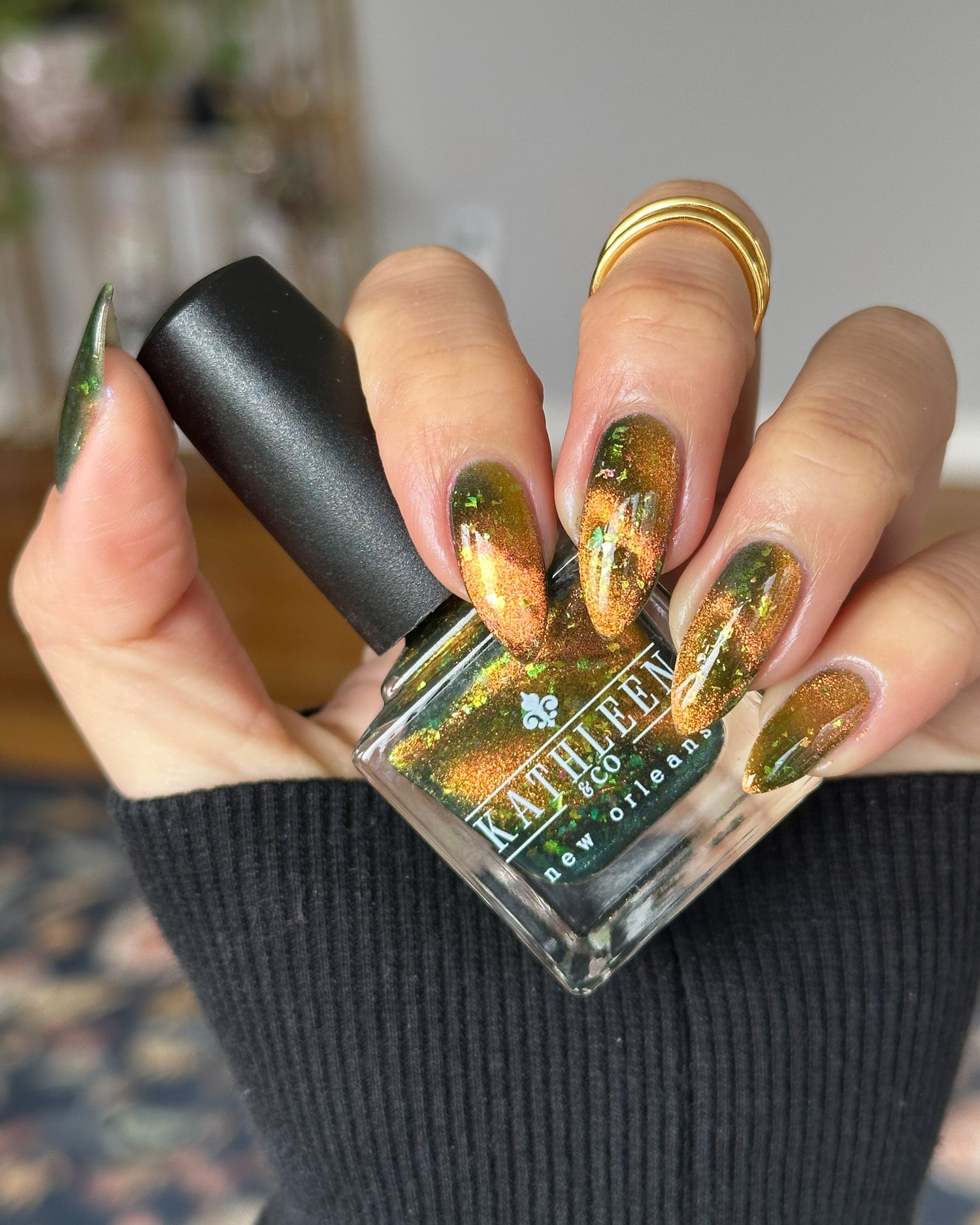 Hand holding a bottle of magnetic nail polish with magnetic finish on  nails.