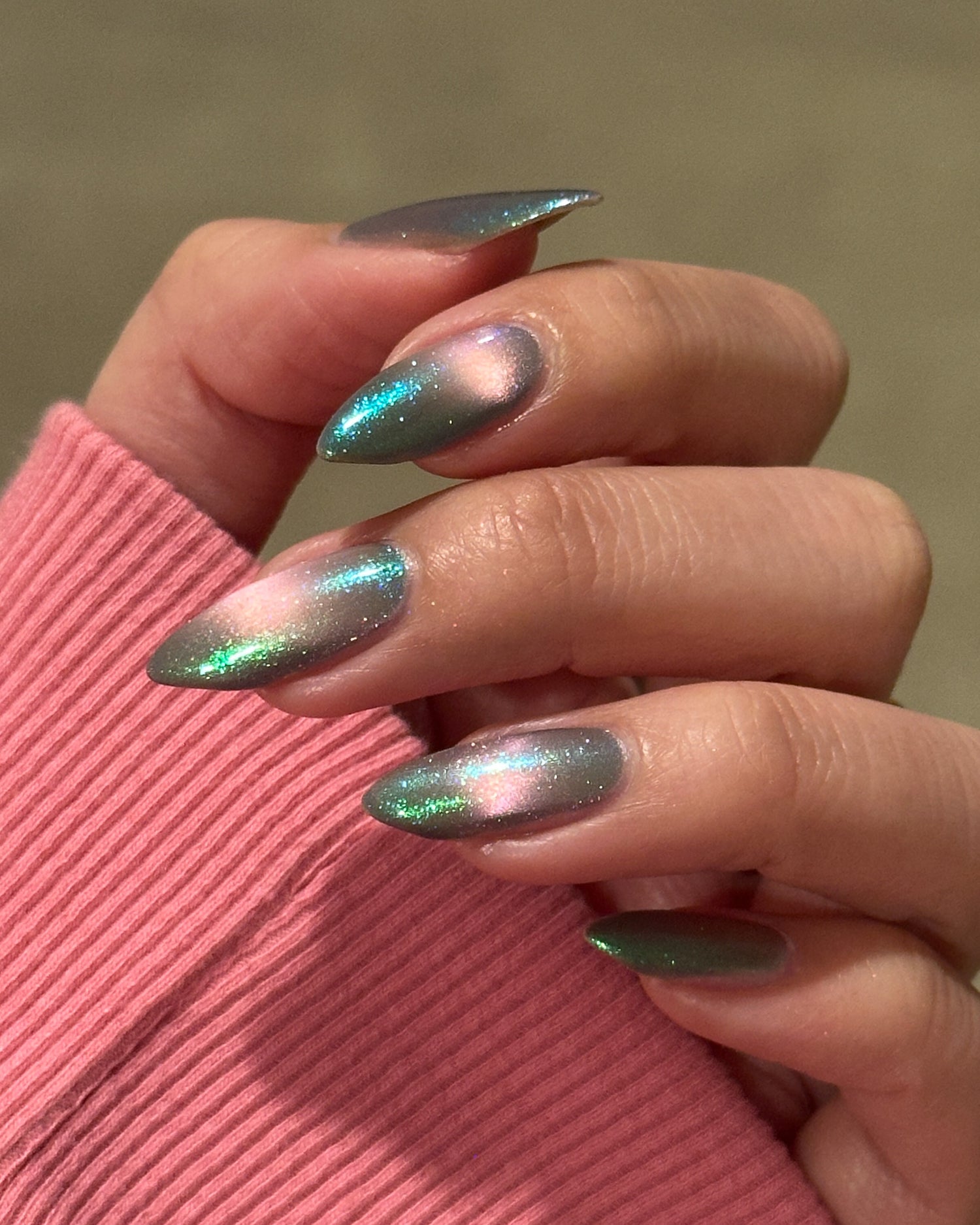 Close-up of a hand with magnetic nail polish on a pink sleeve.