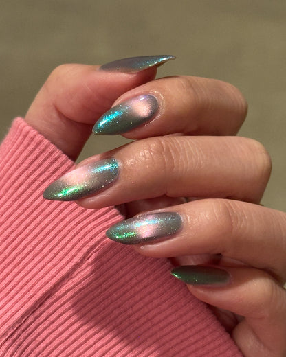 Close-up of a hand with magnetic nail polish on a pink sleeve.