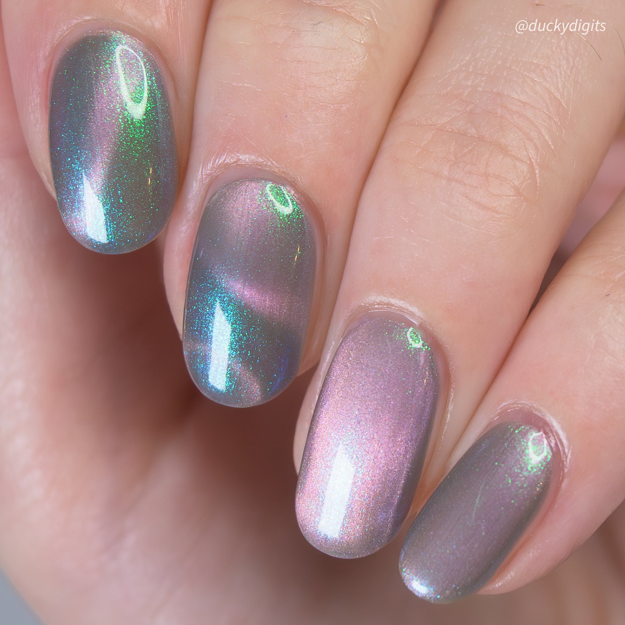 Close-up of a hand with magnetic nail polish on a neutral background