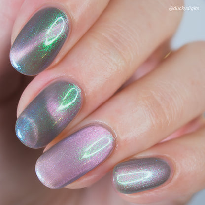 Close-up of a hand with magnetic pink and green nail polish.