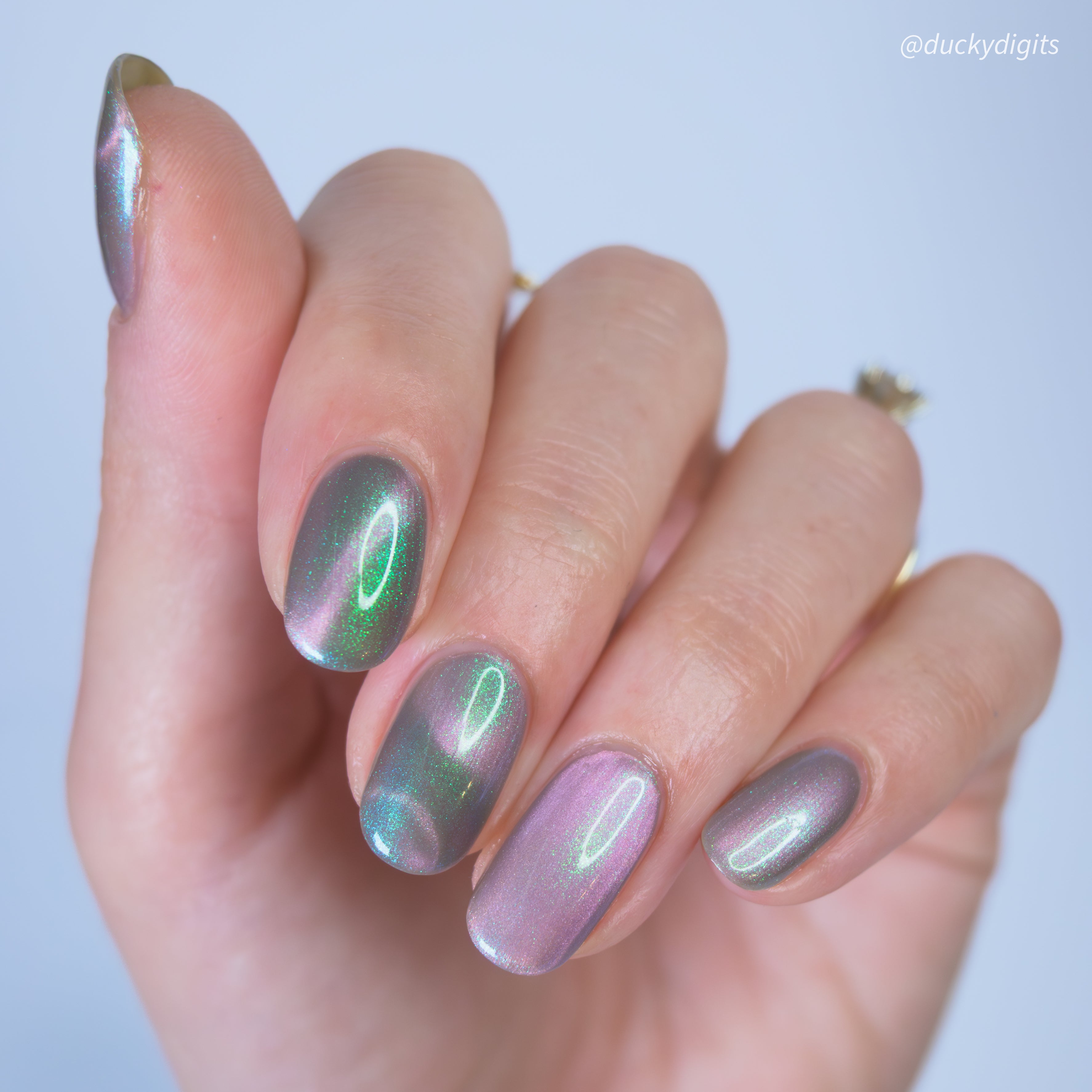 Hand with magnetic nail polish on a light background.