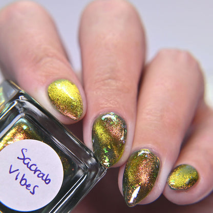 Nails with magnetic gold and green polish and a bottle labeled &