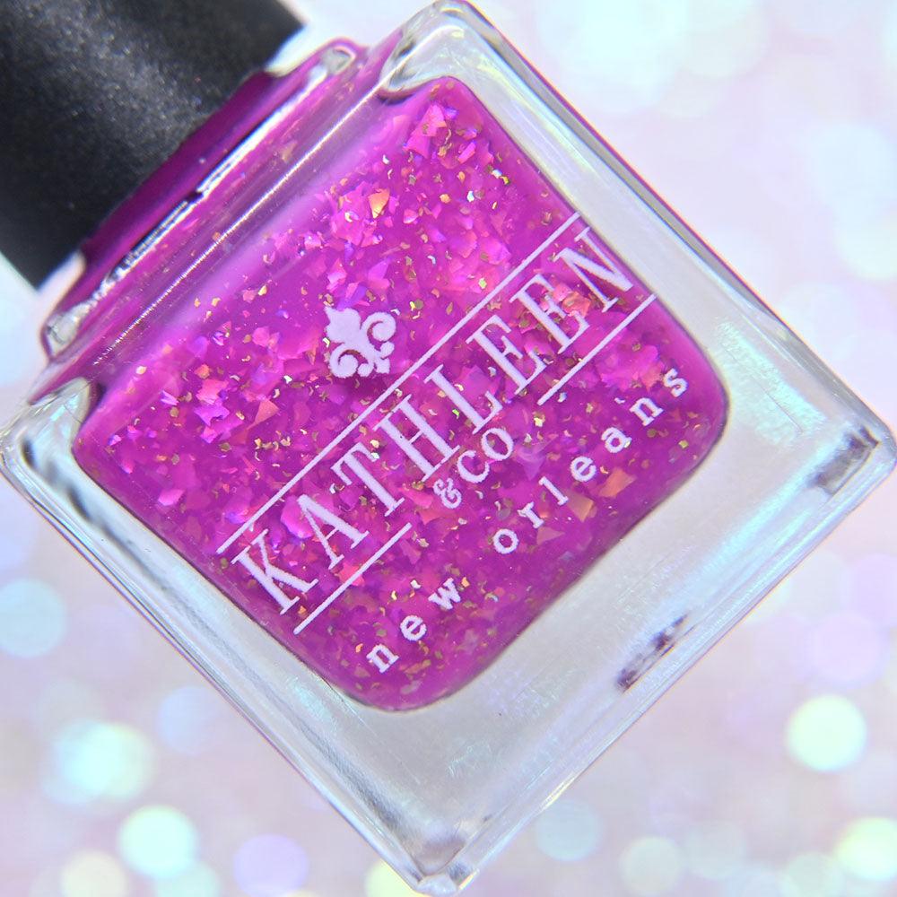 Purple nail polish bottle with glittery content and &