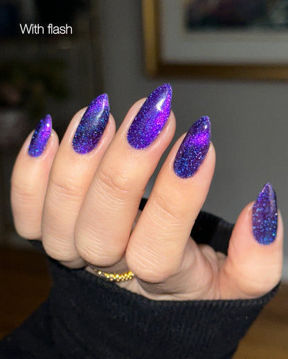 Nails with purple glittery nail polish held by a person.