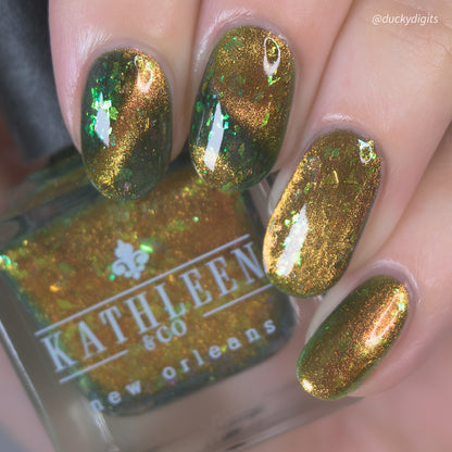Nails with green cateye nail polish and a bottle of Kathleen &amp; Co. nail polish.
