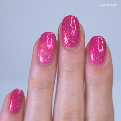 Hand with pink thermal nail polish on a light blue background