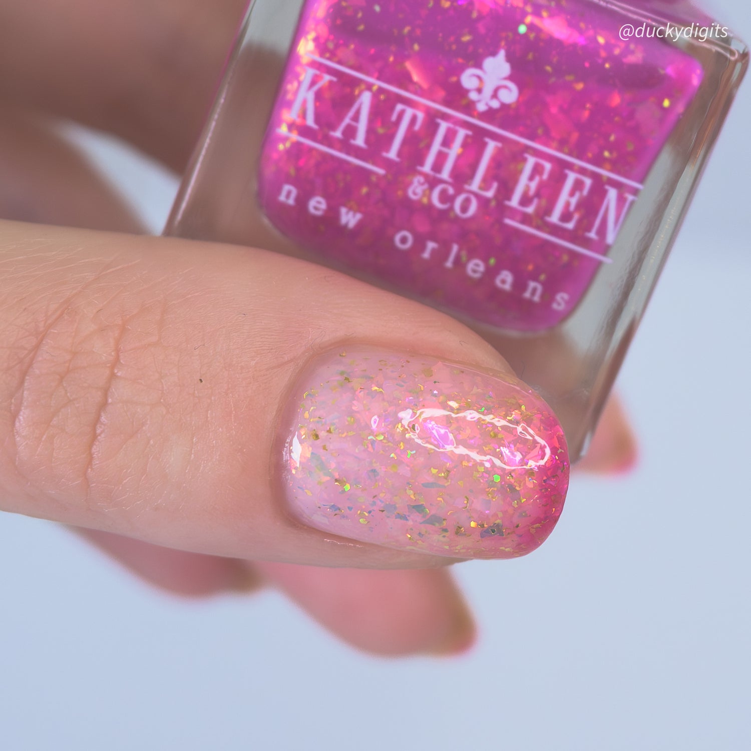 Pink thermal nails with a bottle of Kathleen &amp; Co New Orleans nail polish.