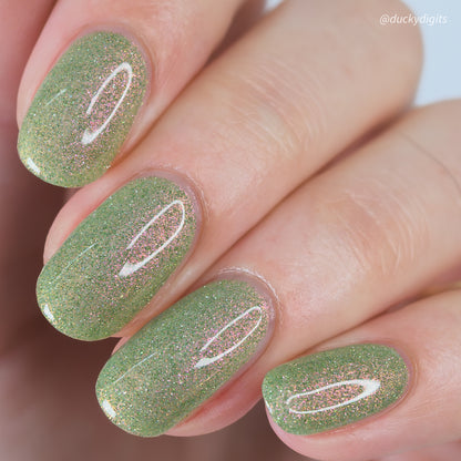 Green reflective glitter nail polish on nails