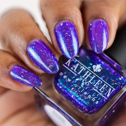 Purple glittery nail polish with a bottle labeled &